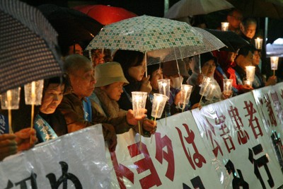 キャンドルをともして座り込む東京大気汚染訴訟の原告ら＝東京都文京区のトヨタ自動車東京本社前で2007年4月9日午後7時9分、山本晋撮影