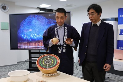 開発した花火の玉皮を手に持って見せる柿木花火工業の柿木博幸社長（左）と龍谷大の中沖隆彦教授＝長浜市高田町の長浜商工会議所で2026年4月23日午後5時3分、長谷川隆広撮影