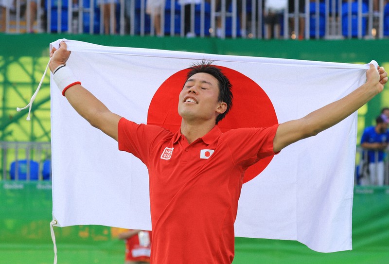 テニス男子で銅メダルを獲得した錦織圭。日の丸を掲げ万感の表情を見せた＝リオデジャネイロの五輪テニスセンターで2016年8月14日、梅村直承撮影