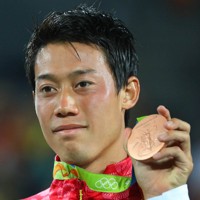 テニス男子シングルスで銅メダルを獲得し、メダルを手に笑顔の錦織圭＝リオデジャネイロの五輪テニスセンターで2016年8月14日、小川昌宏撮影