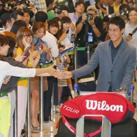 全米テニスで準優勝を果たし、帰国した空港ロビーで、出迎えたファンと握手をする錦織圭選手（右）＝成田空港で2014年9月13日午後4時41分、長谷川直亮撮影