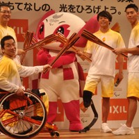 東京パラリンピックの聖火リレーで使うトーチを手にする（右から）テニスの錦織圭選手、パラ陸上の佐藤圭太選手、パラバドミントンの長島理選手、リクシルの瀬戸欣哉会長＝東京都江東区で2019年11月27日午後1時27分、岩壁峻撮影