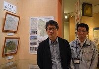 Akifumi Yagi, left, and Yoshinori Inokuma of the Higashikagawa Municipal Board of Education stand beside a display of two visual reconstructions of Hiketa Castle at the city's Museum of History on April 16, 2026. (Mainichi/Masahiko Sasaki)
