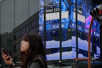 A person stands in front of an electronic stock board showing Japan's Nikkei index at a securities firm, April 30, 2026, in Tokyo. (AP Photo/Eugene Hoshiko)