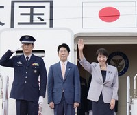Japanese Prime Minister Sanae Takaichi, right, waves as she boards a government plane at Tokyo's Haneda airport on May 1, 2026, to leave for a five-day trip to Vietnam and Australia. (Kyodo)