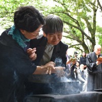 焼香する胎児性患者の坂本しのぶさん（右）＝熊本県水俣市で2026年5月1日午後1時42分、日向米華撮影