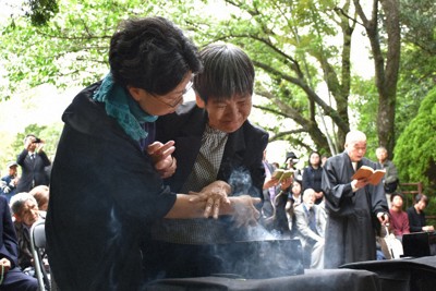 焼香する胎児性患者の坂本しのぶさん（右）＝熊本県水俣市で2026年5月1日午後1時42分、日向米華撮影