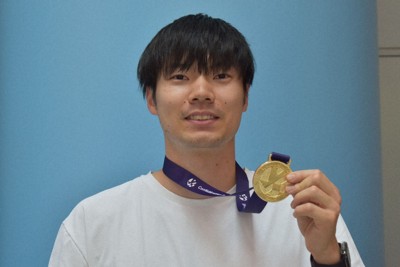 イタリア1部リーグ・セリエAでのシーズンを終えて帰国し、優勝したCEVチャレンジカップのメダルを掲げる大塚達宣選手＝関西国際空港で2026年5月2日、深野麟之介撮影