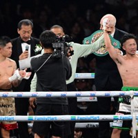 防衛に成功し、手を上げる井上拓真（右）と敗れた井岡一翔（左）＝東京ドームで2026年5月2日、平川義之撮影