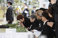 Participants of a memorial service for the victims of Minamata disease, a neurological disorder caused by mercury poisoning, lay flowers and offer prayers in Minamata, Kumamoto Prefecture, on May 1, 2026.(Kyodo)