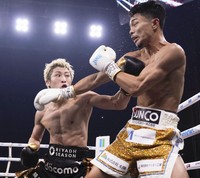 Japanese champion Naoya Inoue, left, throws a punch at compatriot and challenger Junto Nakatani at Tokyo Dome on May 2, 2026. (Kyodo)