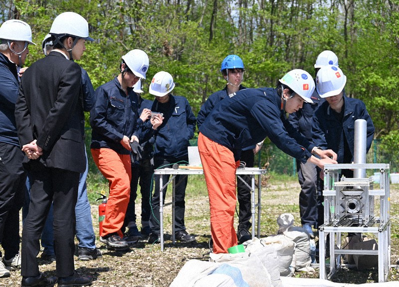 燃焼実験を終えて推力のデータなどを確認する東北大の学生ら＝福島市大笹生のふくしまスカイパークで2026年5月2日、錦織祐一撮影