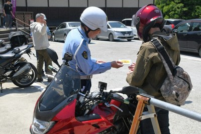 ツーリング客（右）に安全運転を呼び掛ける岩出署員＝岩出市の道の駅ねごろ歴史の丘で2026年5月2日午前11時51分、礒野健一撮影
