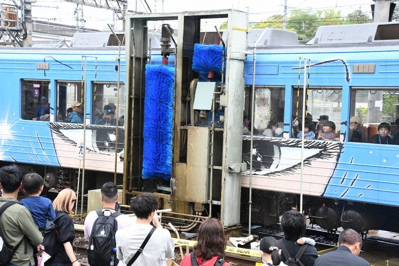 回転する青いブラシを列車の内外で見る子どもら＝三重県伊賀市の上野市車庫で2026年5月3日午前10時48分、大西康裕撮影