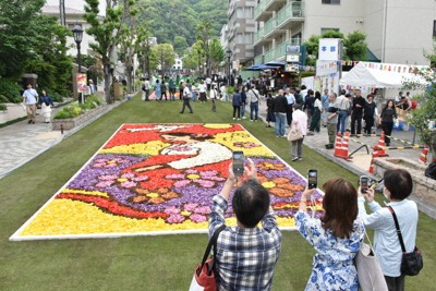 色とりどりのチューリップの花びらを敷き詰めて描いた花絵をスマートフォンで撮影する人たち＝神戸市中央区で2026年5月3日午前11時32分、砂押健太撮影