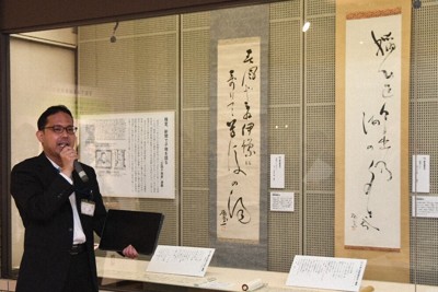 極堂の俳句をしたためた掛け軸の前で、「ほとゝぎす」について解説する平岡瑛二学芸員＝松山市の市立子規記念博物館で2026年4月24日午後2時41分、狩野樹理撮影