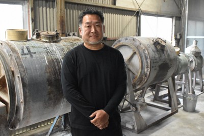 廃業した釉薬会社から引き継いだロールミルの前に立つ山口典宏さん＝三重県菰野町川北で2026年4月30日午後2時41分、荒川基従撮影