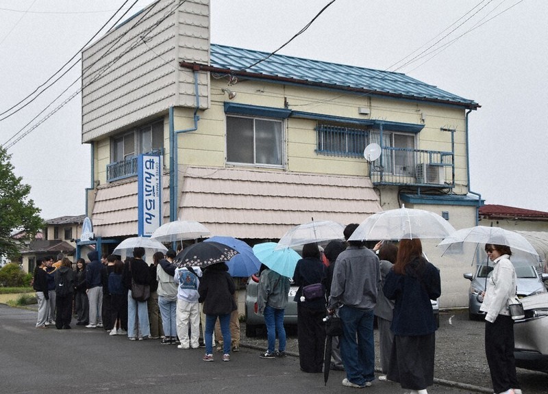 小雨の降るなか傘をさして行列に並ぶドラマのファンら＝山梨県富士吉田市で2026年4月30日、杉本修作撮影