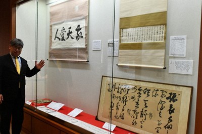 西郷隆盛の書などが並ぶ展示品を前に今後の企画の構想を練る吉満庄司館長＝鹿児島市上竜尾町の西郷南洲顕彰館で2026年4月22日、藤野智成撮影