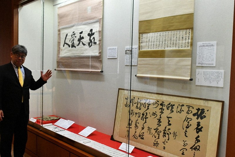 西郷隆盛の書などが並ぶ展示品を前に今後の企画の構想を練る吉満庄司館長＝鹿児島市上竜尾町の西郷南洲顕彰館で2026年4月22日、藤野智成撮影