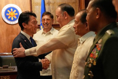 フィリピンのテオドロ国防相に出迎えられる小泉進次郎防衛相（左）＝マニラで2026年5月5日、ロイター