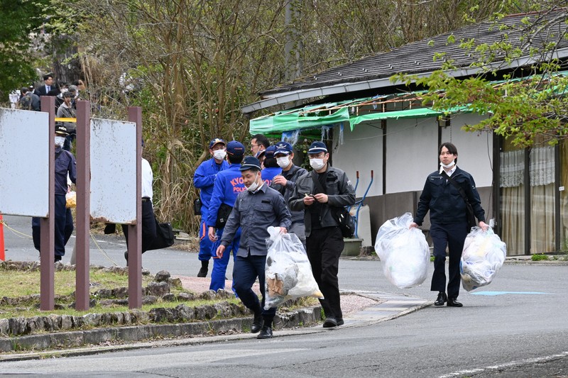 観光地「るり渓」の公衆トイレ周辺の検証現場から出てくる京都府警の捜査員ら＝京都府南丹市園部町大河内で2026年4月18日午後1時37分、資野亮太撮影