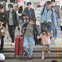 大型連休のUターンが始まり、大きな荷物を持ってJR博多駅の階段を下りる人たち＝福岡市博多区で2026年5月5日午前11時47分、野田武撮影