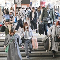 大型連休のUターンが始まり、大きな荷物を持ってJR博多駅の階段を下りる人たち＝福岡市博多区で2026年5月5日午前11時32分、野田武撮影