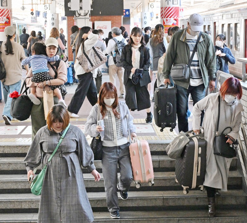 大型連休のUターンが始まり、大きな荷物を持ってJR博多駅の階段を下りる人たち＝福岡市博多区で2026年5月5日午前11時32分、野田武撮影