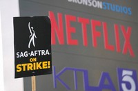 A picketer carries a sign on the picket line outside Netflix, Sept. 27, 2023, in Los Angeles. (AP Photo/Chris Pizzello, File)