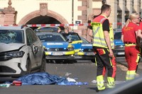 Rescue workers stand next to a damaged car that has crashed into several people in Leipzig, Germany, May 4, 2026. (Sebastian Willnow/dpa via AP)