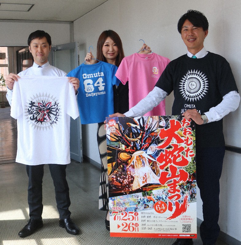 2026年の大蛇山Tシャツをまとう城戸信清・実行委員長（右）ら＝大牟田市庁舎渡り廊下で2026年4月3日、降旗英峰撮影