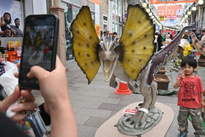 恐竜の模型と写真を撮ってもらう子供＝長崎市浜町で2026年5月5日午後0時57分、百田梨花撮影