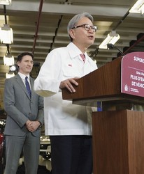 This file photo shows Honda Motor Co. President Toshihiro Mibe (R) announcing an electric vehicle investment plan in April 2024 with then Canadian Prime Minister Justin Trudeau in Ontario. (Kyodo) 