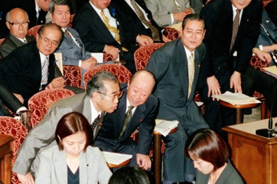進んできた分権改革との整合性が課題に。1999年に地方分権一括法案が参院委員会で可決され、成立を控え頭を下げる小渕恵三首相（当時）ら＝同年7月8日正午すぎ、西村剛撮影