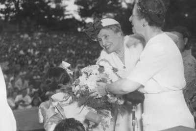 1948年に来日し、少女から花束を受け取るヘレン・ケラー。右は秘書のトムソン