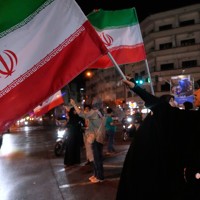 街中で国旗を振るイランの体制支持者＝テヘランで2026年5月8日、AP