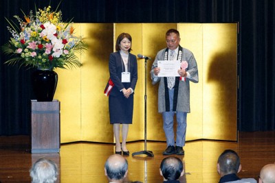 ユネスコ無形文化遺産の「山・鉾・屋台行事」に追加登録され、認定証を手にする放生津八幡宮曳山・築山保存会の中野剛副会長（右）＝新潟県村上市で、共同