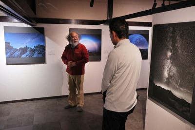 展示された作品の前でギャラリートークを行う大西浩次さん（左）＝長野県白馬村で2026年5月9日、手塚耕一郎撮影