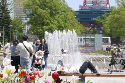 夏さながらの日差しの下、大通公園で思い思いに過ごす人たち＝札幌市中央区で2026年5月12日午前11時44分、水戸健一撮影