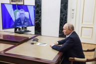 ロシア軍戦略ミサイル部隊司令官から報告を受けるプーチン大統領＝12日、モスクワ（タス＝共同）