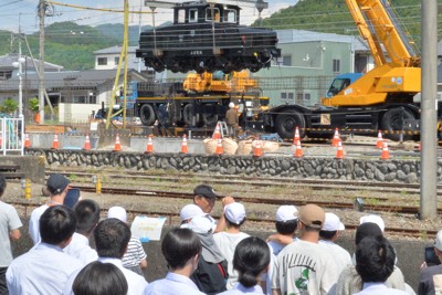 下仁田町に運ばれ、クレーンで宙づりにされる電気機関車「デキ」の設置作業を見守る小中学生＝下仁田町で2026年5月13日午前9時8分、庄司哲也撮影