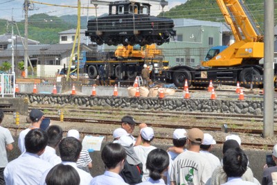 下仁田町に運ばれ、クレーンで宙づりにされる電気機関車「デキ」の設置作業を見守る小中学生＝下仁田町で2026年5月13日午前9時8分、庄司哲也撮影