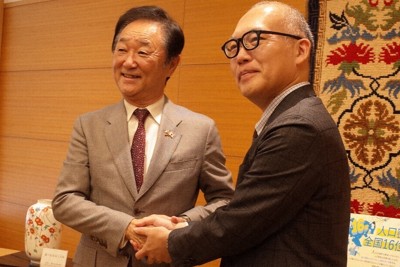 引馬誠也副知事（右）と握手を交わす三井所嘉彦名誉領事＝佐賀市で2026年5月13日午前10時43分、西貴晴撮影