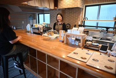 マジー・ノアールからプレゼントされたカウンターテーブルに立つ西牧純さん（奥）＝福島市大町の「Jun’s　Cafe」で2026年5月12日午後4時33分、錦織祐一撮影