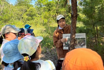 2025年7月開催時に、子どもたちが植生を再生させる取り組みを学ぶ様子＝瀬戸内オリーブ基金提供