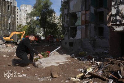 ロシアの攻撃を受けたキーウの集合住宅前で献花するウクライナのゼレンスキー大統領＝2026年5月15日、ウクライナ非常事態庁提供・ロイター